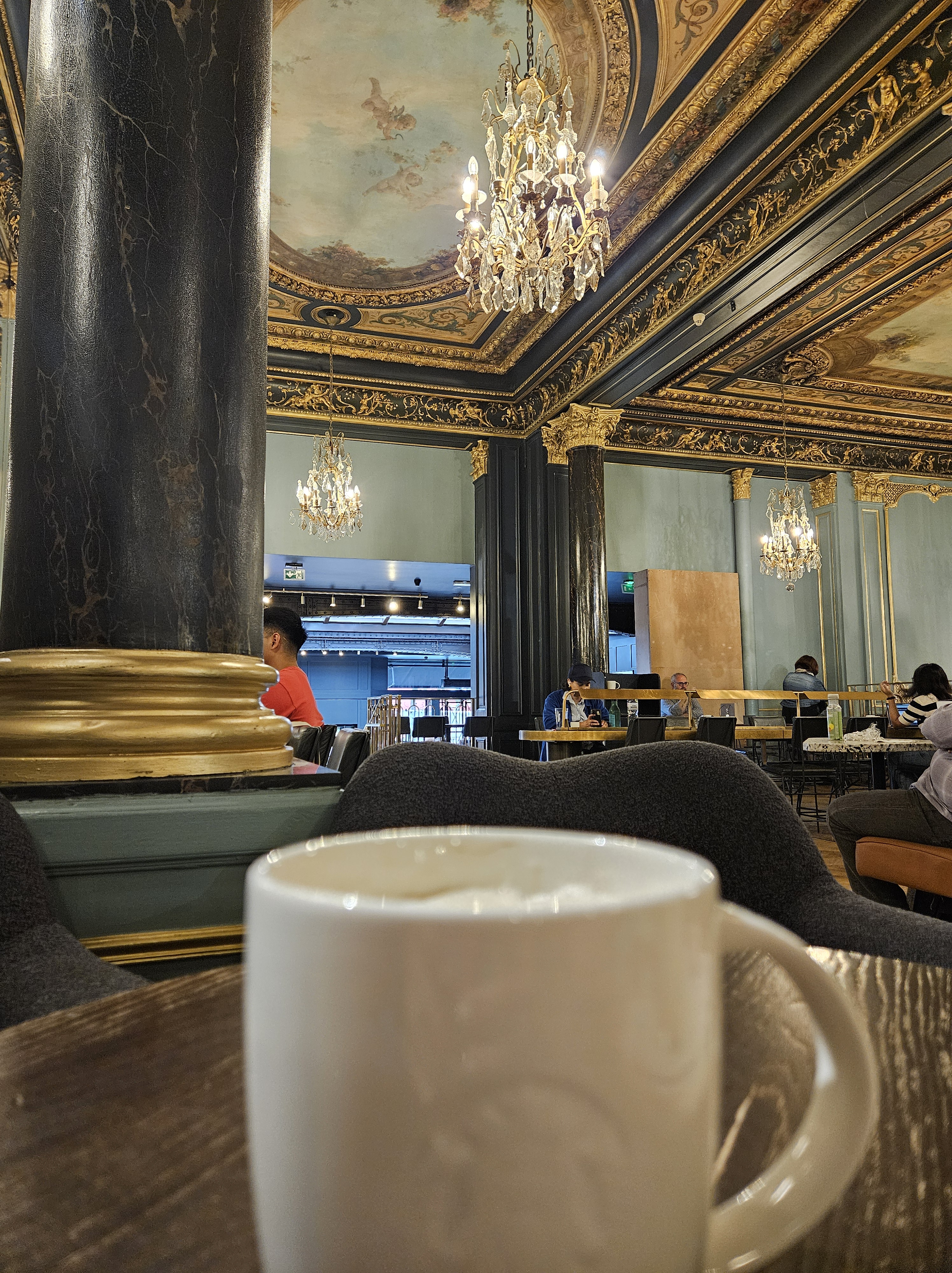 Cup of coffee with shop in background.